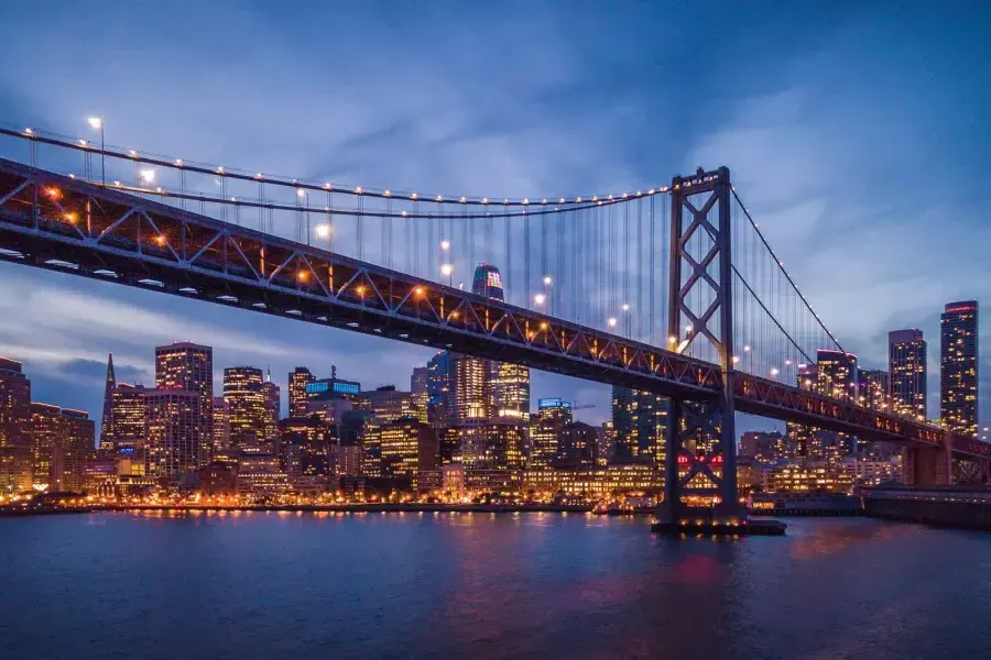 The Bay Bridge and Embarcardero waterfront lit up at night.